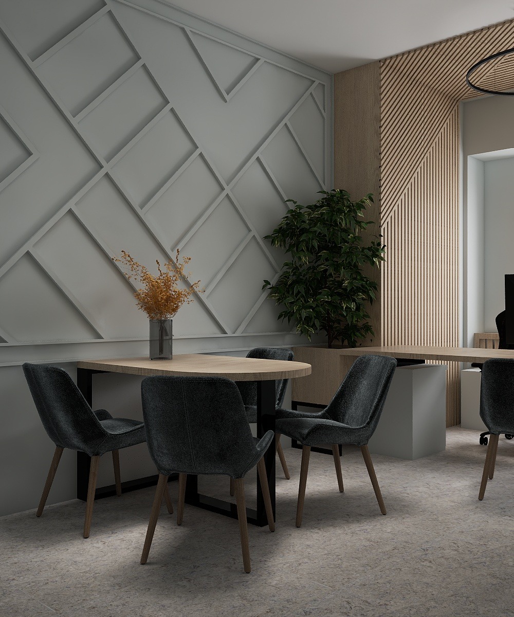 Stylowa aranżacja biura: stół z krzesłami na tle ściany z geometrycznym wzorem i drewnianej boazerii. Wazon z suchymi kwiatami i zielona roślina dodają charakteru.