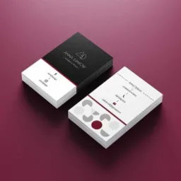 Dwa stosy wizytówek na bordowym tle. Jedna wizytówka z czarnym tłem w górnej części i białym w dolnej, z logo i danymi kontaktowymi. Druga wizytówka biała z szarymi i bordowymi elementami...