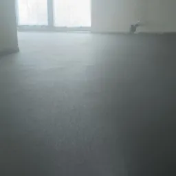 Świeżo wylana, mokra powierzchnia podłogi w pomieszczeniu z oknami zabezpieczonymi folią. Widoczny słup konstrukcyjny oraz rury wystające ze ściany.