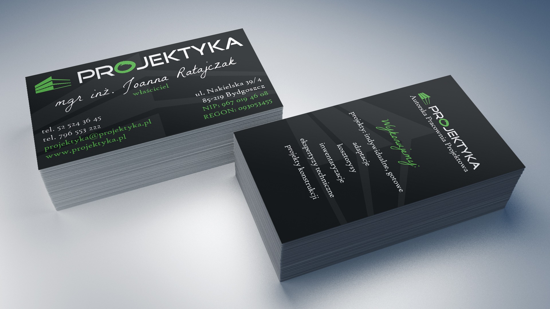 Dwa stosy wizytówek firmy Projektyka z czarnym tłem i zielonym akcentem w logo, prezentujące dane kontaktowe i zakres usług.