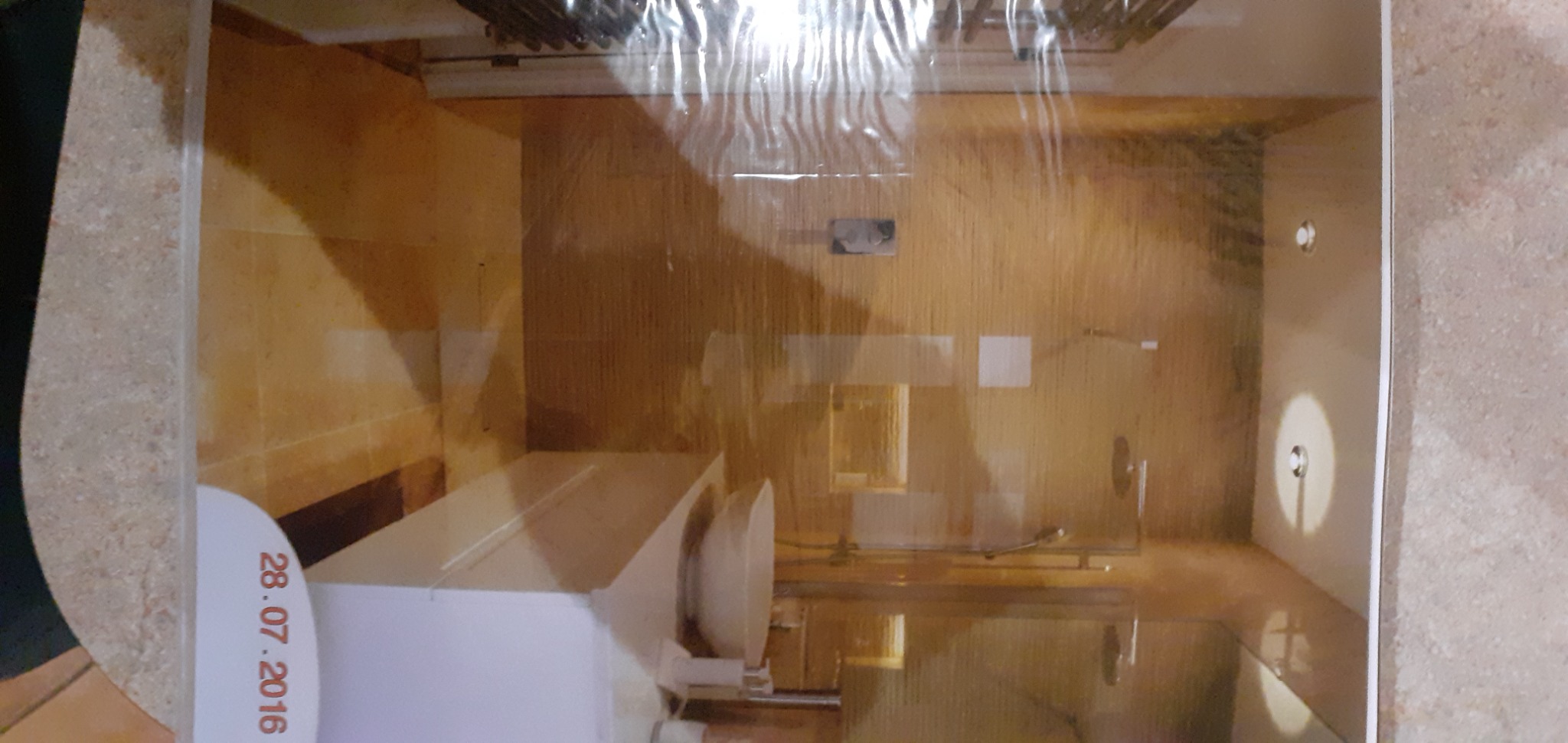 Ukończona łazienka z beżowymi płytkami, widoczna umywalka, lustro i oświetlenie punktowe, zdjęcie z datą 28.07.2016 w rogu.