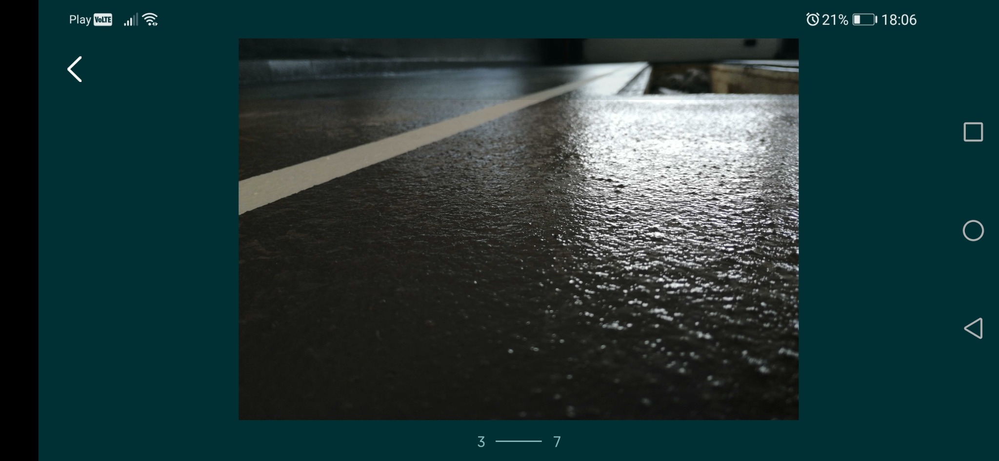 Świeżo wylana, mokra posadzka z wyraźną, białą linią podziału, widoczne refleksy światła.