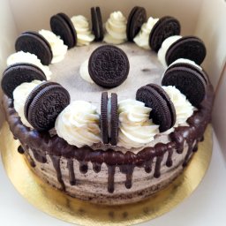 Catering Czary Mary Bożena Hanak - Tort Oreo z kremem śmietankowym i polewą czekoladową, udekorowany ciasteczkami Oreo w pudełku.