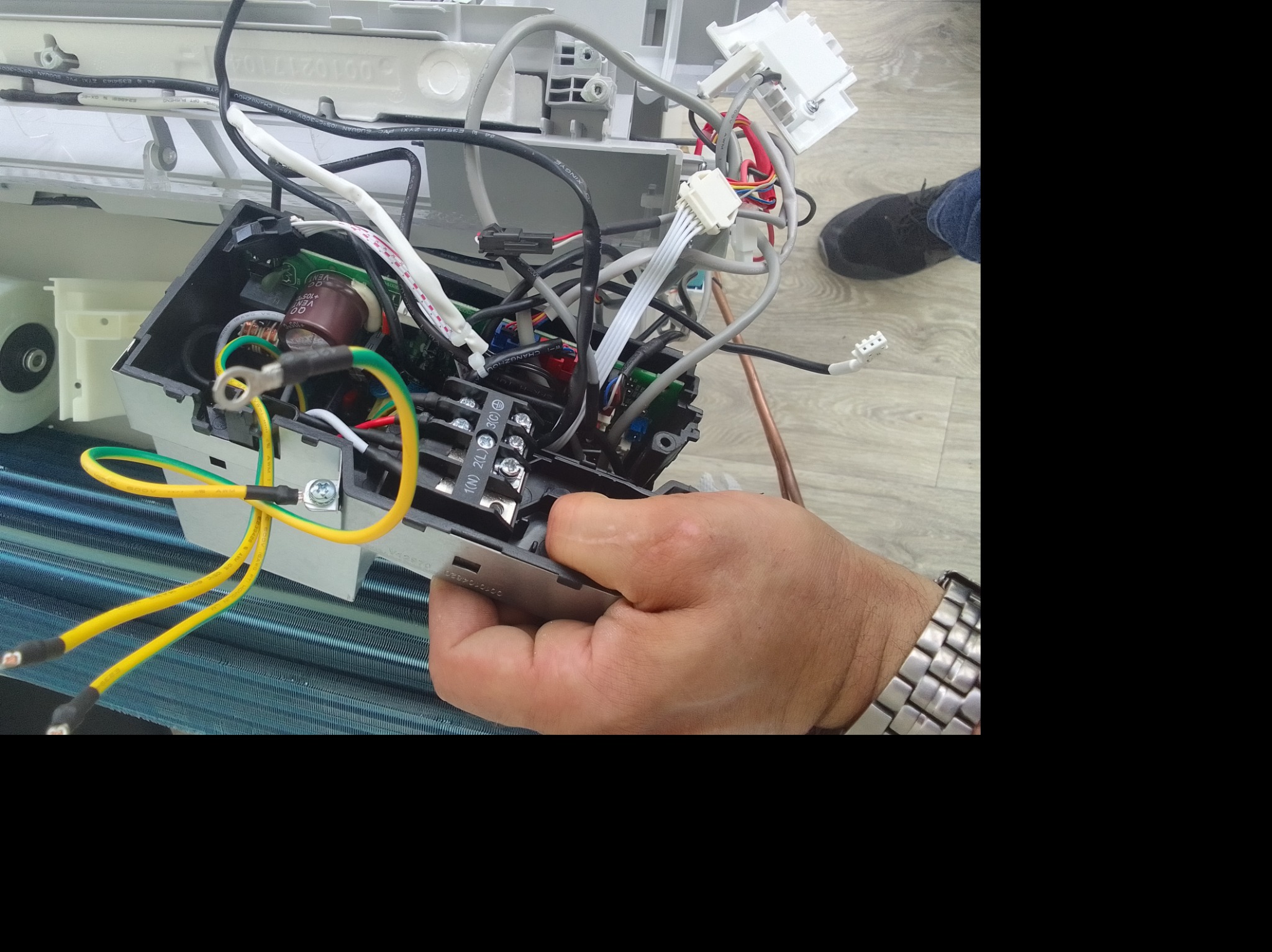 Elektryk w Lublinie diagnozuje i naprawia elektryczne podzespoły klimatyzacji, widoczne kable, złączki i płytka drukowana.