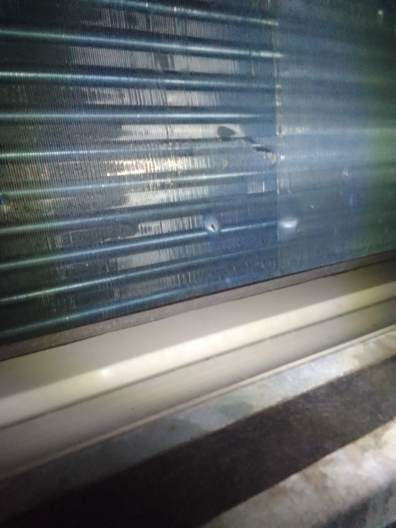 Zanieczyszczone i uszkodzone lamele wymiennika ciepła klimatyzacji, widoczne ślady korozji i zarysowania.