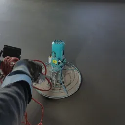 Zacieraczka mechaniczna w trakcie pracy na szarej posadzce jastrychowej, widoczna ręka operatora w roboczej rękawicy.