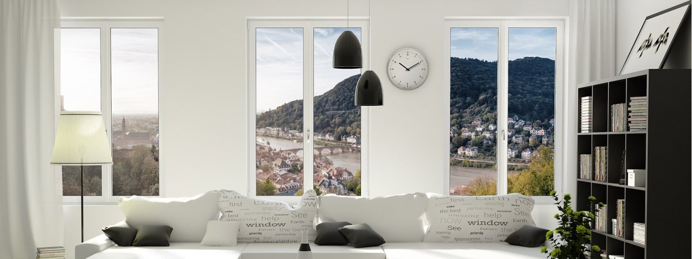 Jasne wnętrze z trzema oknami PCV z widokiem na miasto z rzeką i wzgórzami, biała sofa z poduszkami z nadrukiem słowa 'window', czarne wiszące lampy i zegar na ścianie.