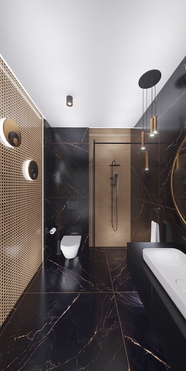 Nowoczesna łazienka z czarnymi płytkami imitującymi marmur, złotymi akcentami w oświetleniu i dekoracyjnej ścianie z rattanowej plecionki, kabina prysznicowa typu walk-in z czarną ramą.