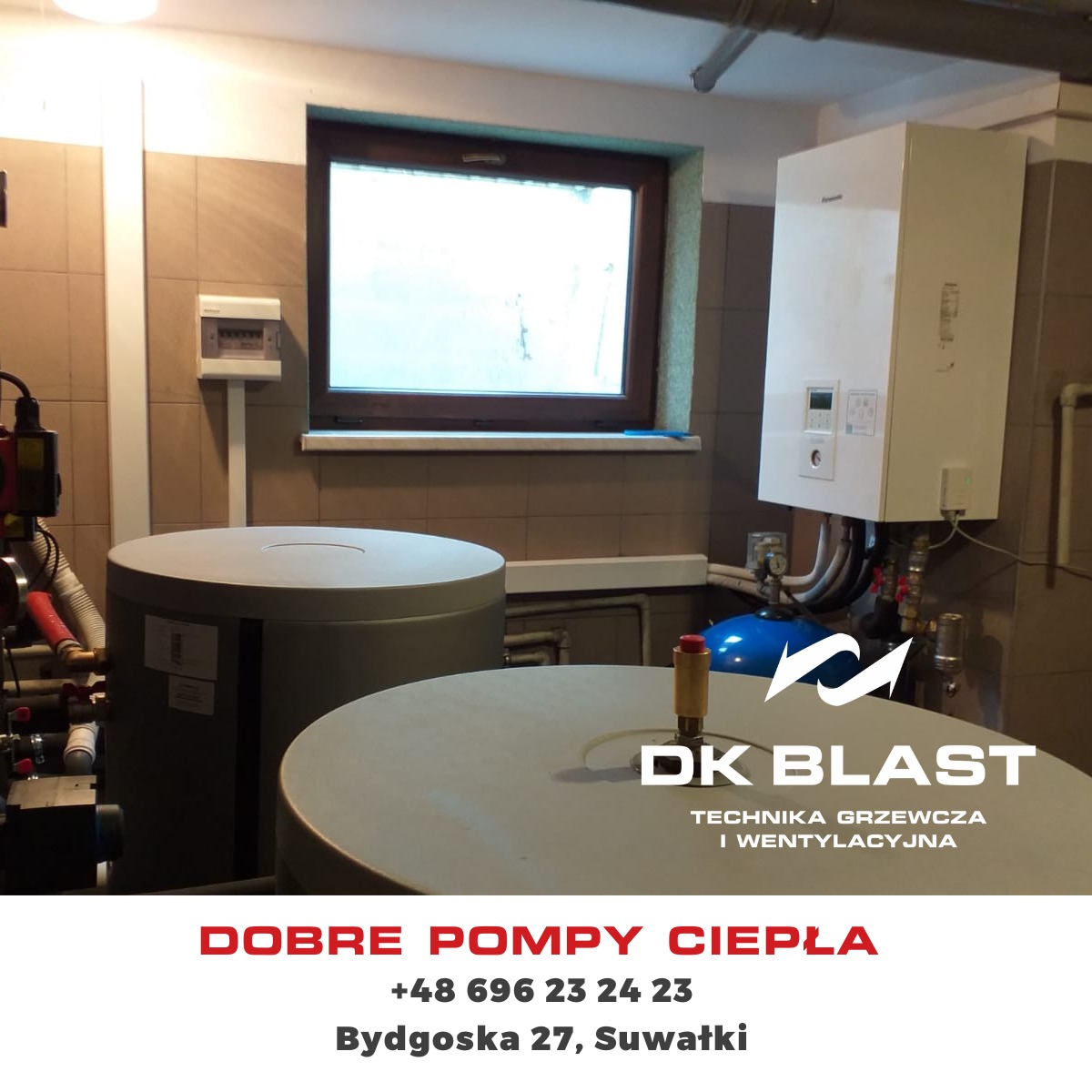 Instalacja pompy ciepła w pomieszczeniu technicznym z widocznymi zbiornikami akumulacyjnymi, kotłem grzewczym i przewodami hydraulicznymi. Na pierwszym planie logo firmy instalacyjnej.