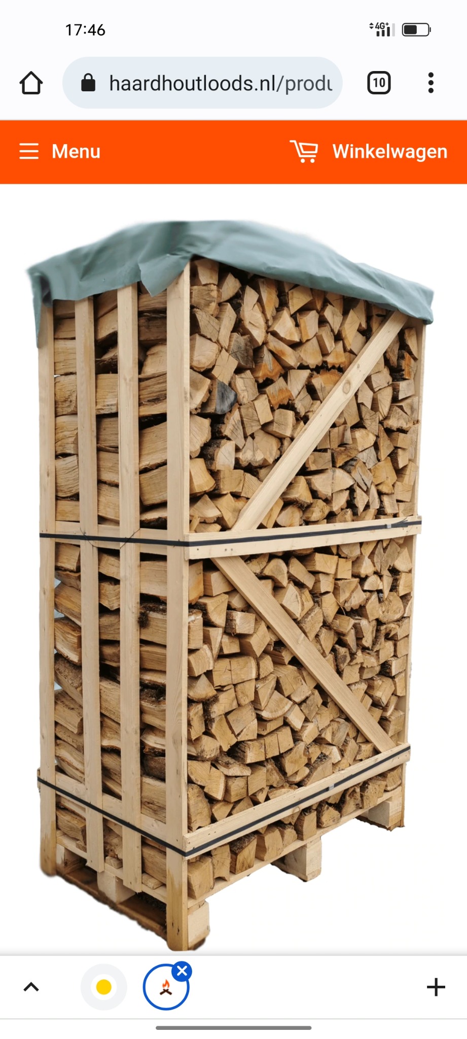 Paleta drewna pociętego na kawałki, ułożonego w drewnianej skrzyni, zabezpieczona zieloną plandeką na górze.