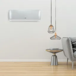 Nowoczesny, srebrny klimatyzator Hyundai zamontowany na białej ścianie w pokoju z drewnianą podłogą, obok stolika i lamp wiszących.