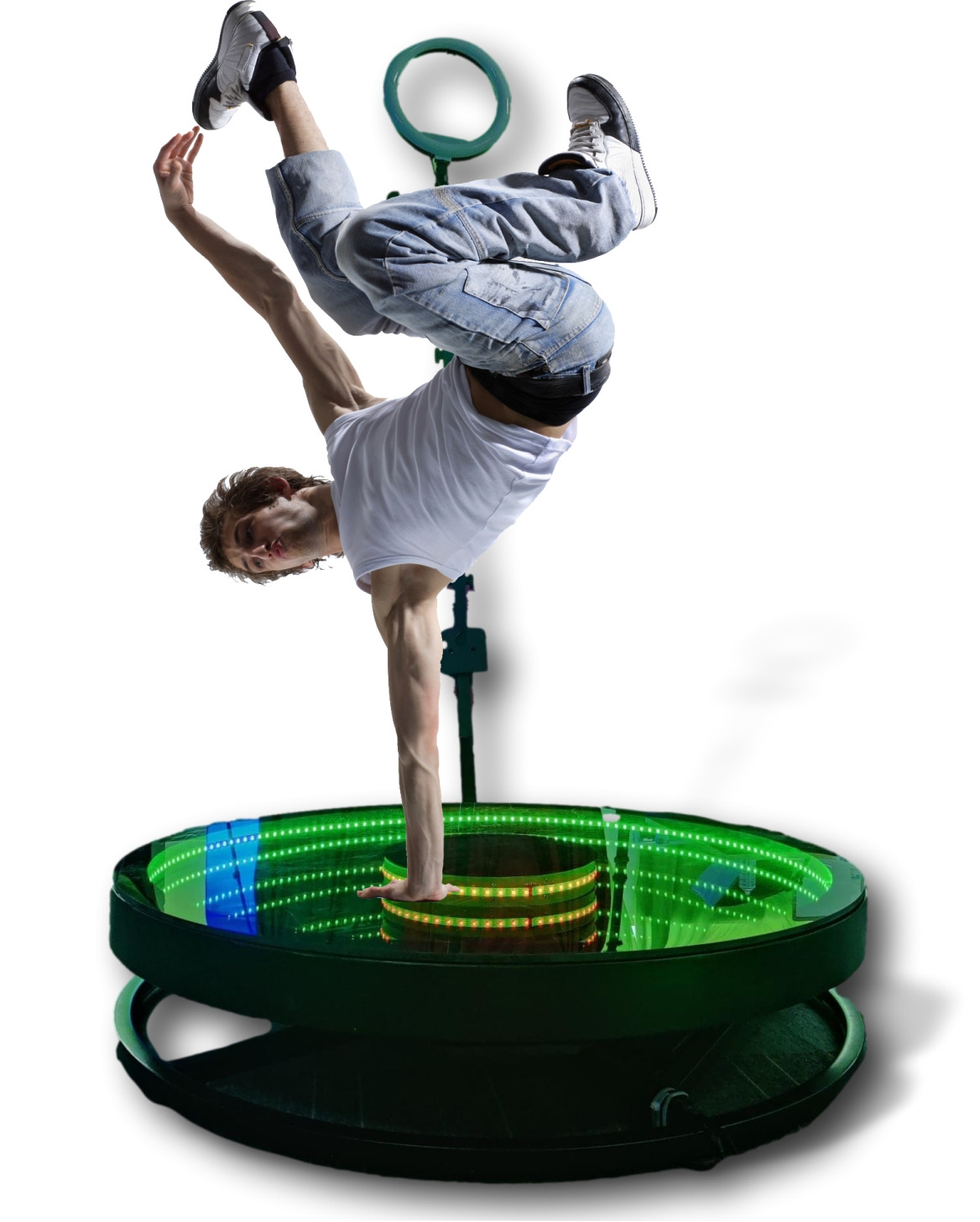 Mężczyzna wykonuje akrobatyczny taniec na obrotowej platformie z podświetleniem LED, ubrany w białą koszulkę i dżinsy.