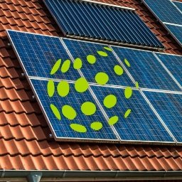 FotonTech Sp. z.o.o - Panele słoneczne i kolektory słoneczne na dachu z czerwonej dachówki, z nałożonym zielonym logo z kropek.