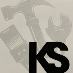 Logo firmy z narzędziami: młotek, klucz i pędzel malarski w tle, z czarnym napisem 'KS' na pierwszym planie.