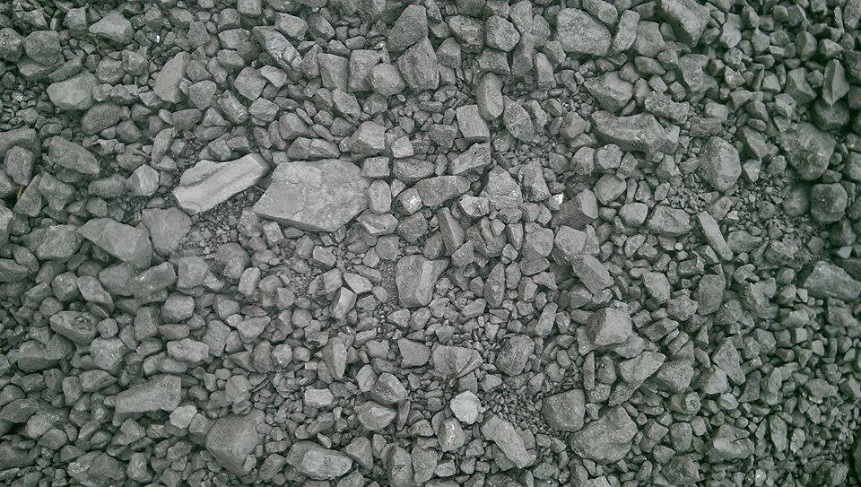 Drobny, szary materiał opałowy o nieregularnych kształtach, wypełniający całą powierzchnię kadru.