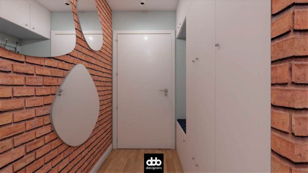 Korytarz z ceglaną ścianą, asymetrycznym lustrem i białą szafą z siedziskiem.