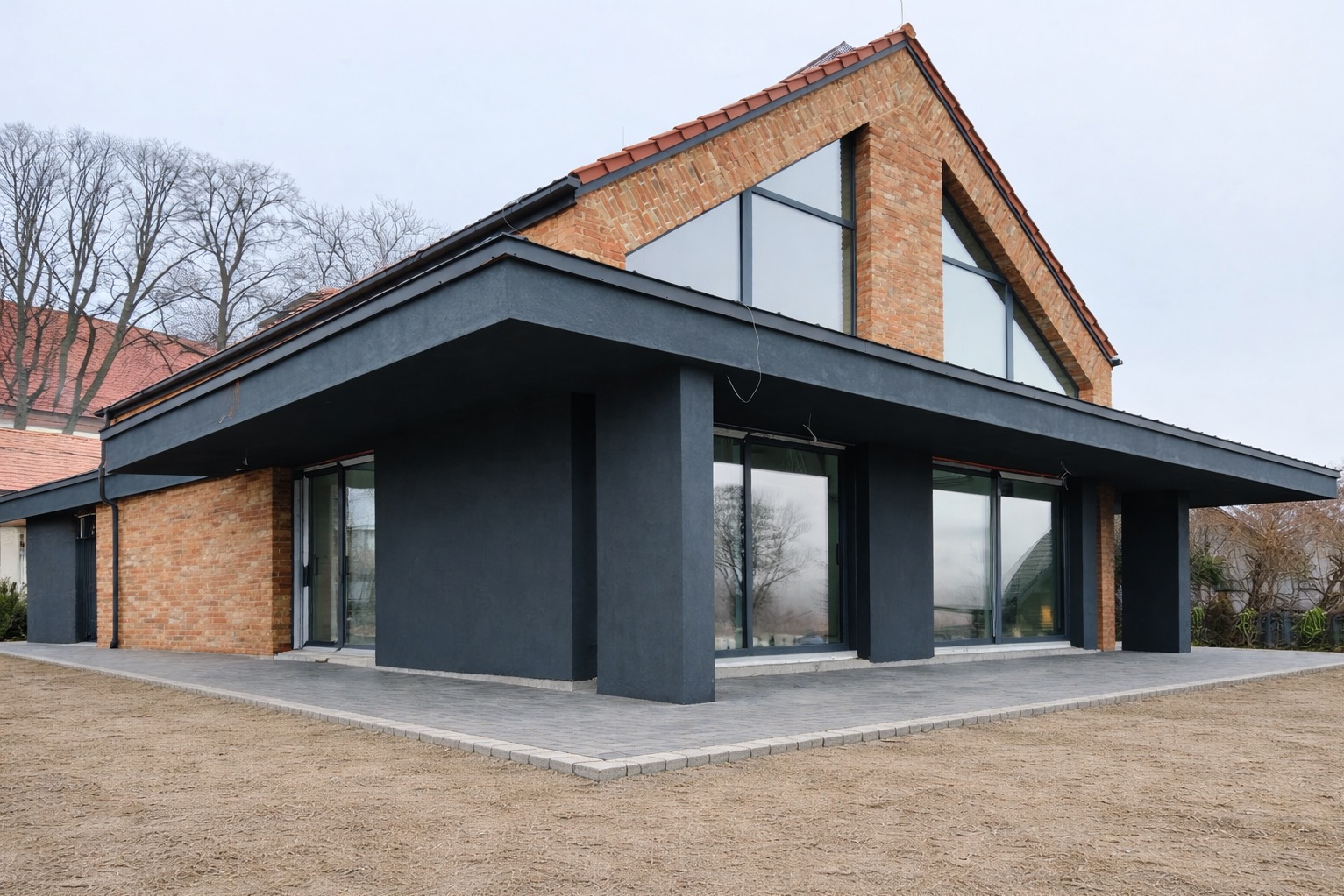Nowoczesny dom z cegły klinkierowej z dużymi oknami i ciemną elewacją, widok z zewnątrz na świeżo ułożony chodnik z kostki brukowej. Minimalistyczny design.