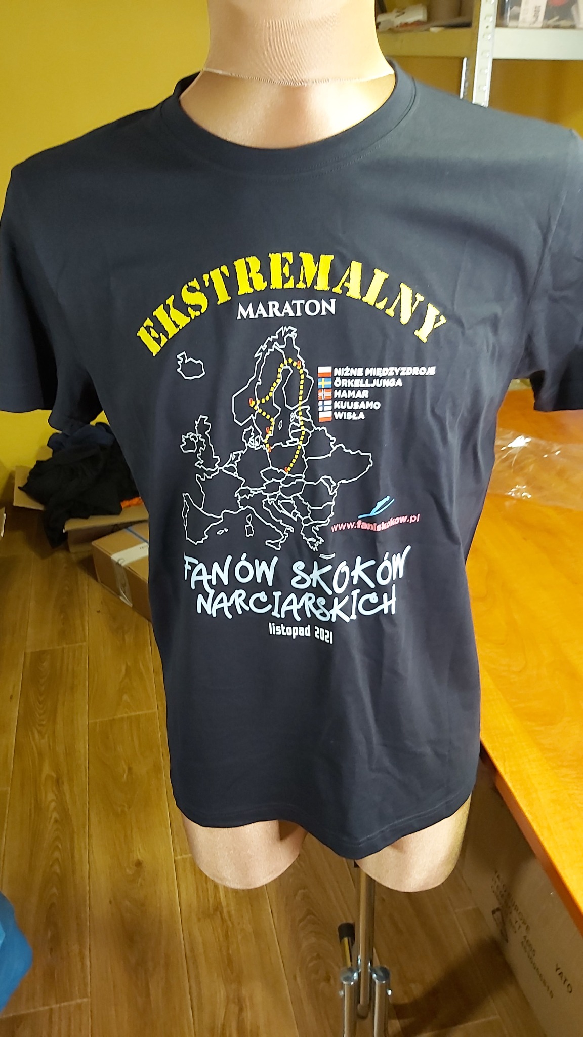 Czarna koszulka z nadrukiem mapy Europy i napisem 'Ekstremalny Maraton Fanów Skoków Narciarskich listopad 2021', prezentowana na manekinie.