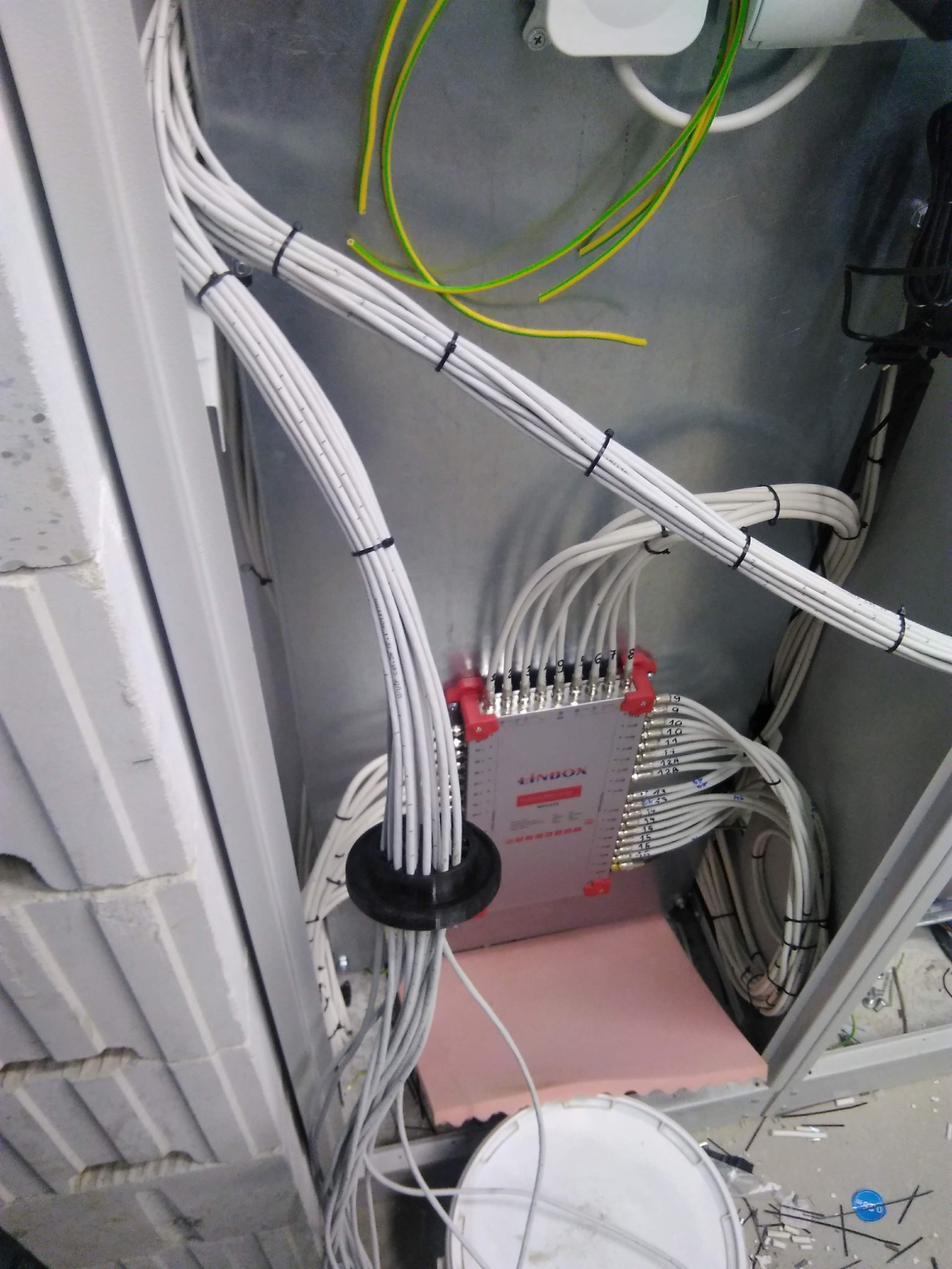 Rozdzielnica sygnałowa LINBOX z podłączonymi kablami, przymocowanymi opaskami zaciskowymi, widoczne numery portów, instalacja w trakcie realizacji.