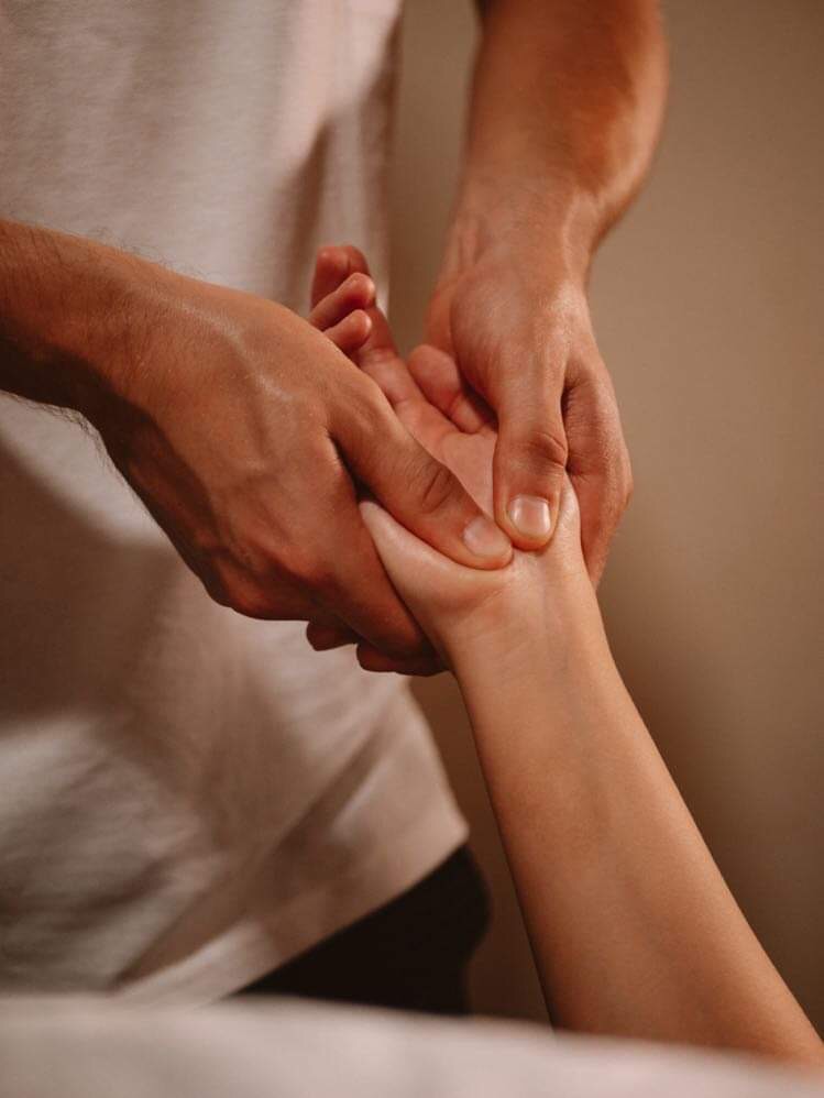 Terapeuta uciska punkt na dłoni pacjenta podczas zabiegu manualnego, skupienie na precyzyjnym ucisku i kontakcie dłoni