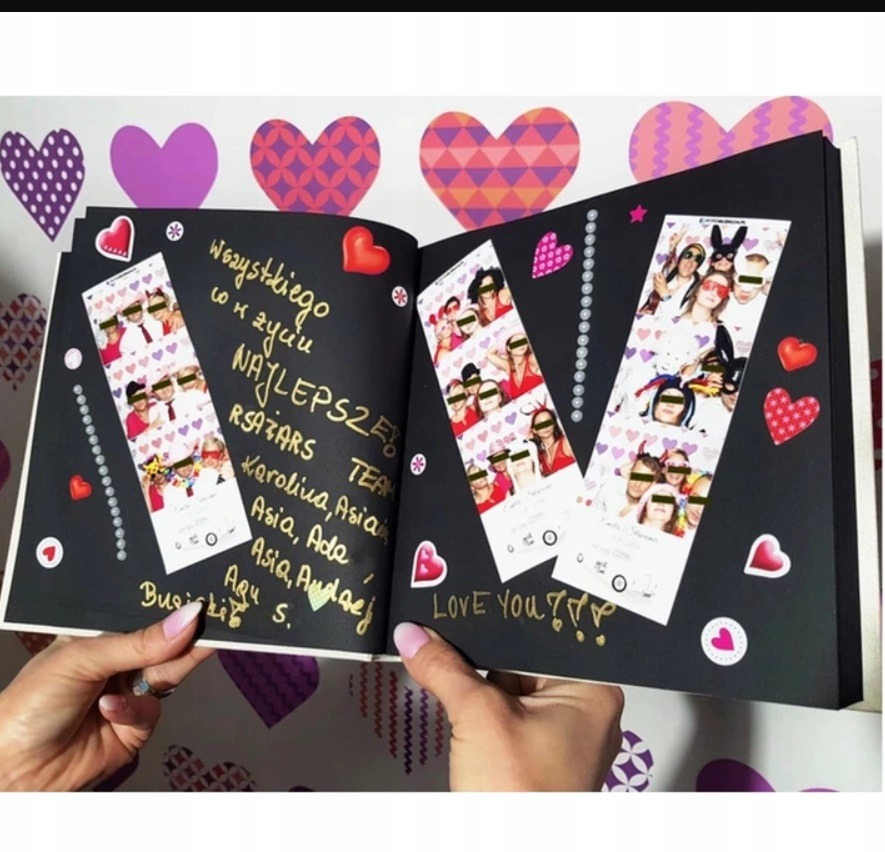 Album ze zdjęciami z sesji zdjęciowej w Warszawie, ozdobiony naklejkami w kształcie serc i napisami wykonanymi złotym markerem, trzymany w dłoniach.