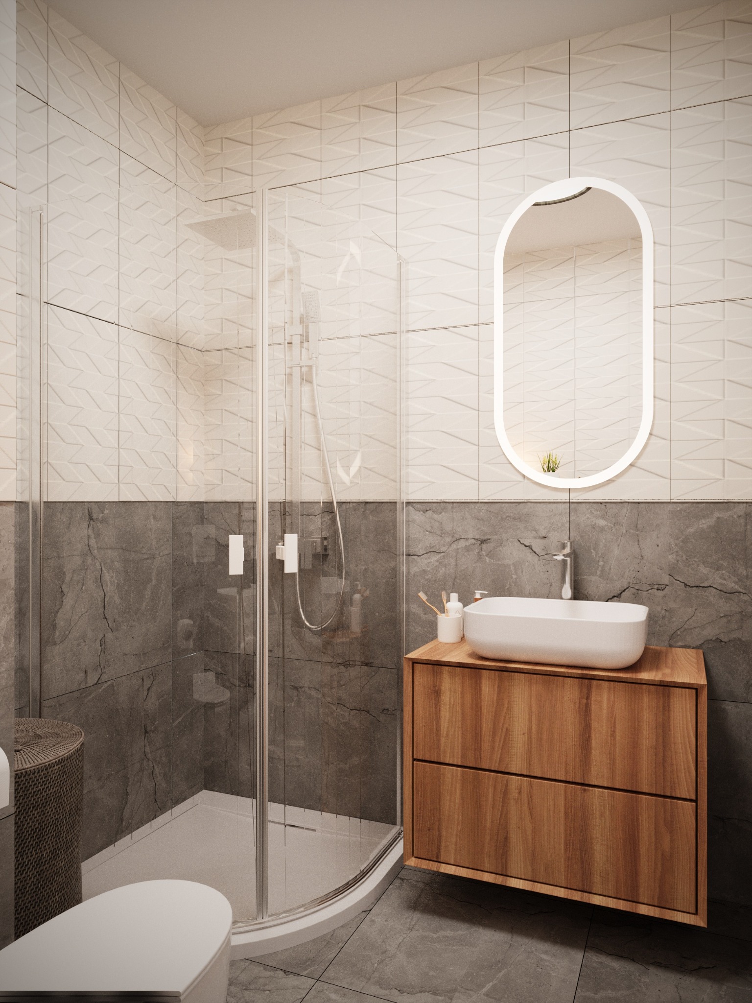 Nowoczesna łazienka z kabiną prysznicową, umywalką na drewnianej szafce i podświetlanym lustrem owalnym, wykończona płytkami w dwóch odcieniach szarości, z dekoracyjną fakturą na górnej części ścian.