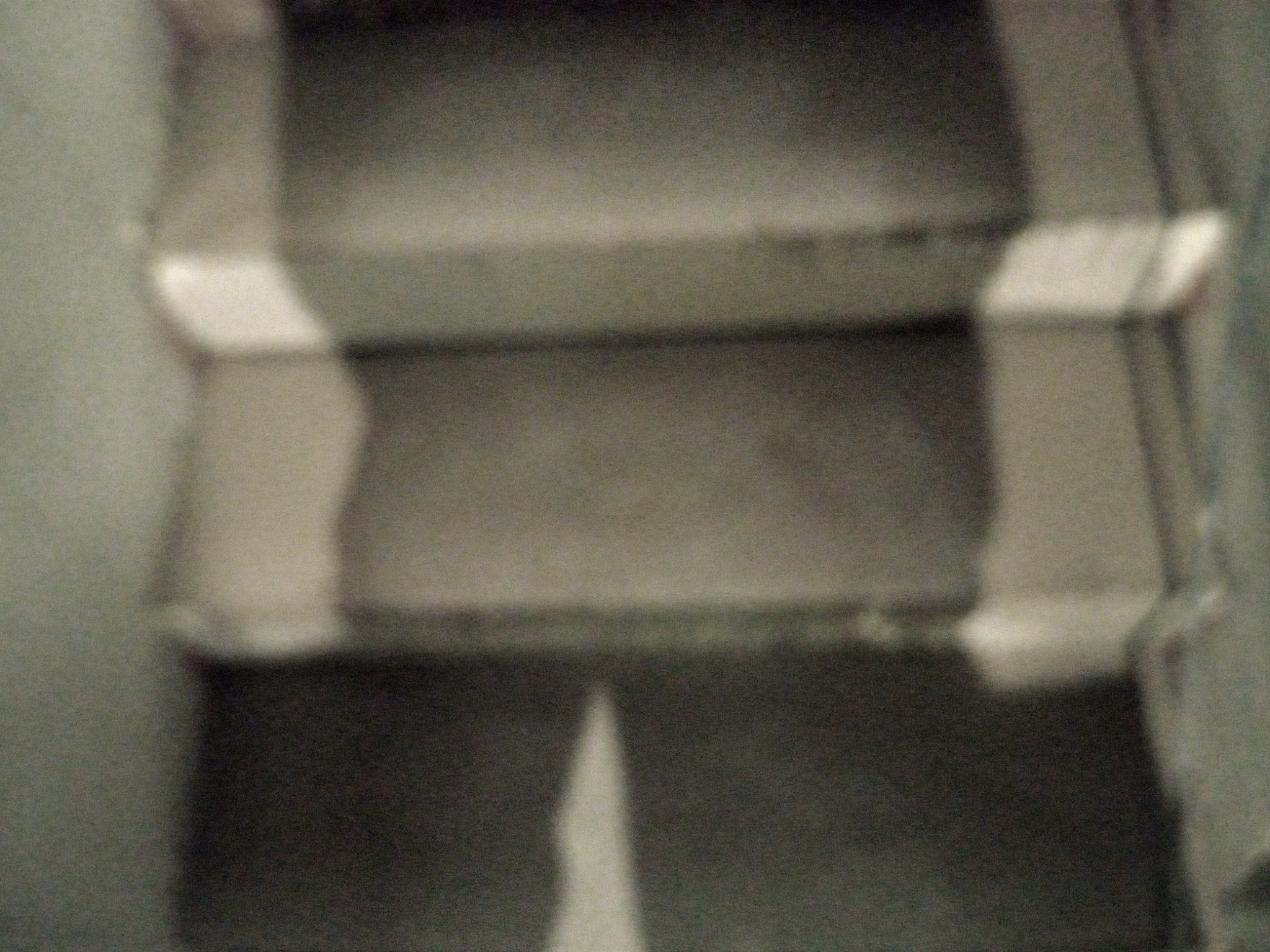 Rozmyte ujęcie fragmentu sufitu z widocznym podziałem na segmenty, słabe oświetlenie.