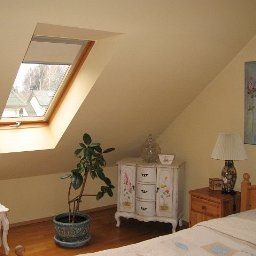 Tomasz mal - Pokój na poddaszu z oknami dachowymi, ściany pomalowane na kremowo, drewniana podłoga, meble w stylu vintage i dekoracje.