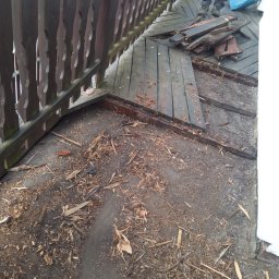 Kowalik Mateusz - Demontaż drewnianej podłogi balkonu z widocznymi deskami i fragmentami konstrukcji, przygotowanie do remontu.