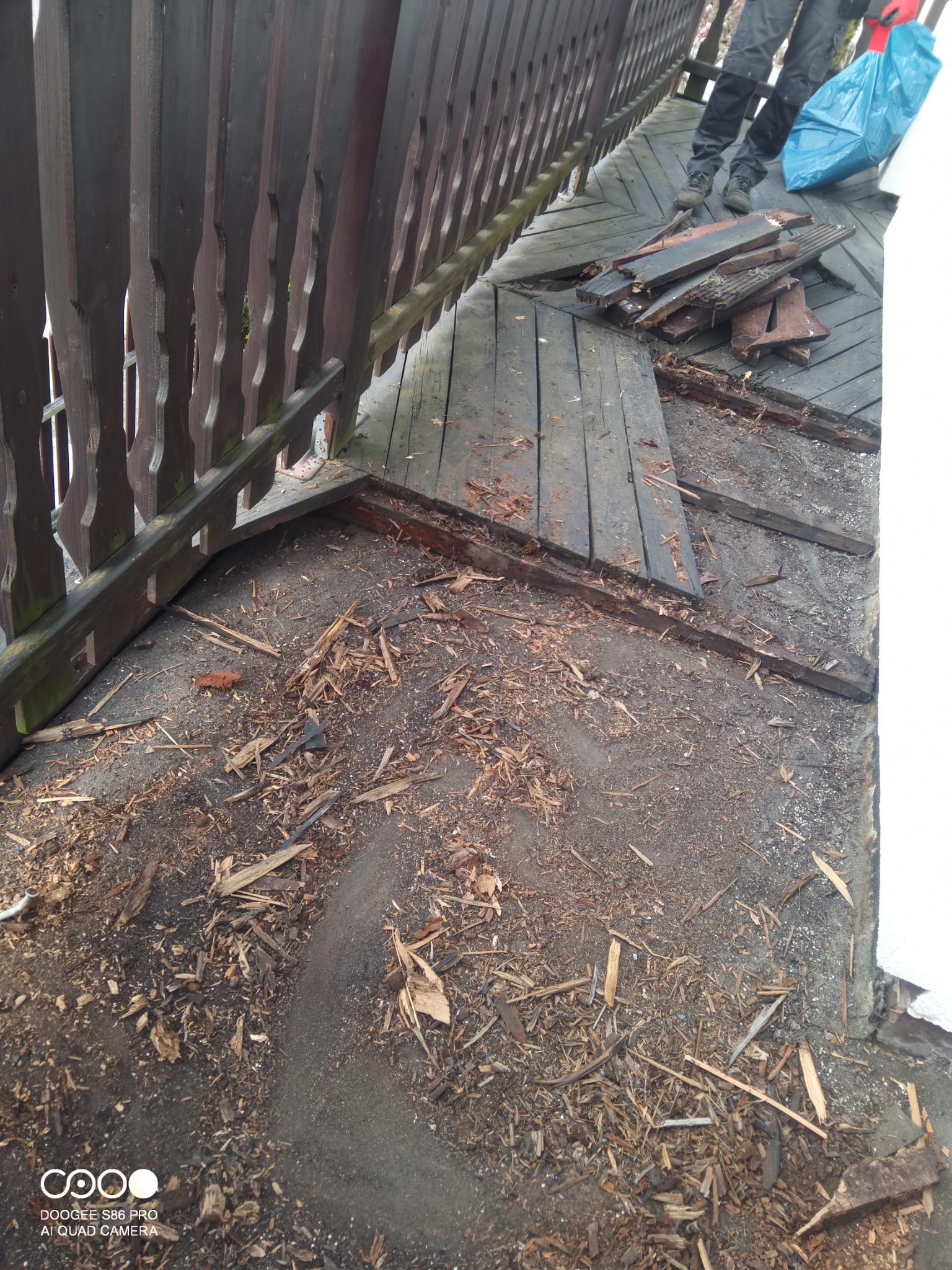 Demontaż drewnianej podłogi balkonu z widocznymi deskami i fragmentami konstrukcji, przygotowanie do remontu.