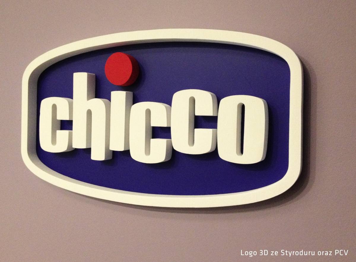 3D logo Chicco wykonane ze styroduru i PCV, z białymi literami na niebieskim tle, otoczone białą obwódką, zamontowane na szarej ścianie.