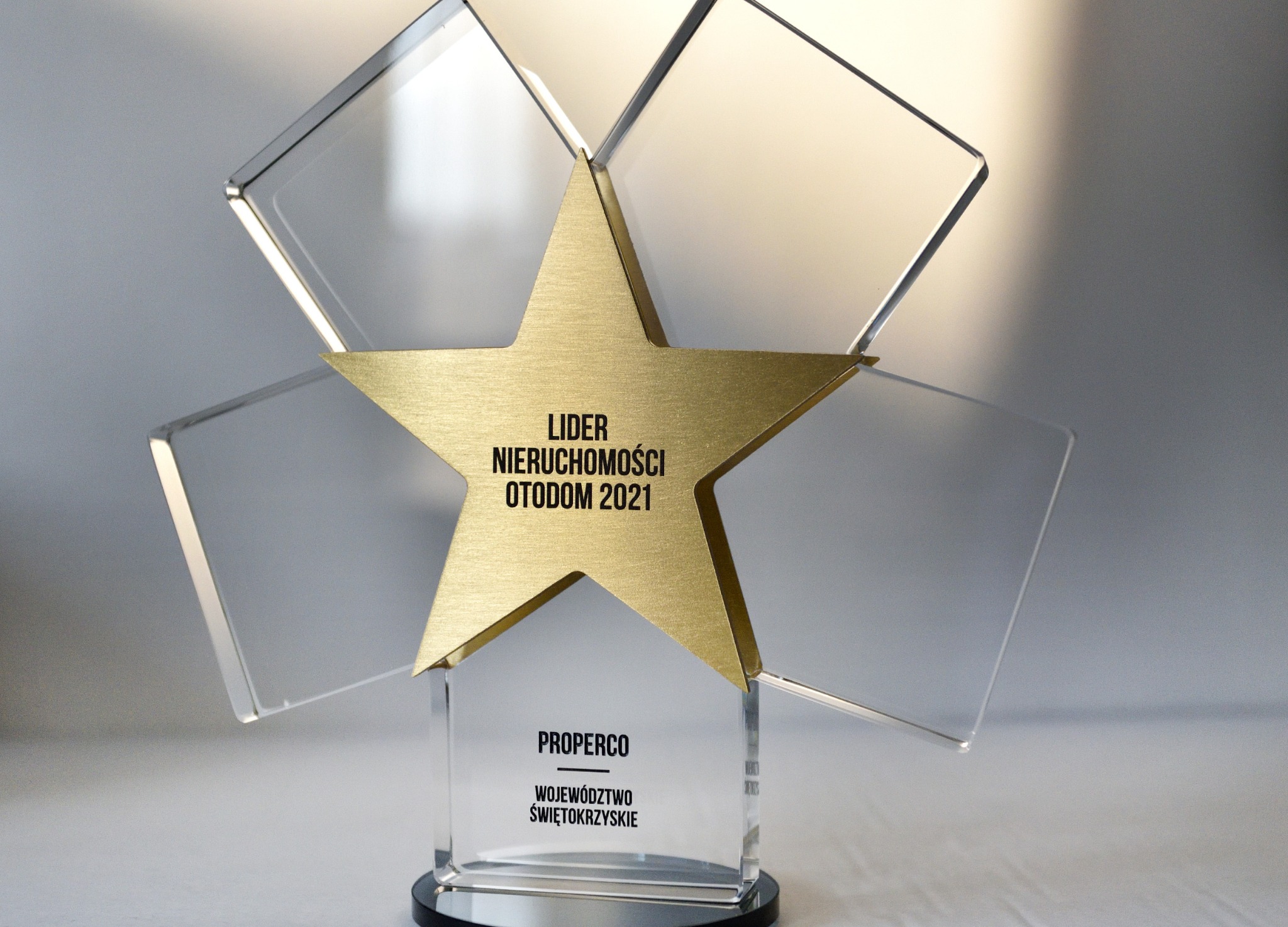 Szklana statuetka 'Lider Nieruchomości Otodom 2021' z złotą gwiazdą i napisem 'PROPERCO', symbolizująca nagrodę dla firmy z województwa świętokrzyskiego.