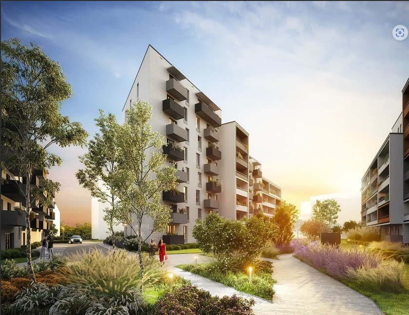 Wizualizacja osiedla mieszkaniowego we Wrocławiu z nowoczesną architekturą, jasną elewacją, ciemnymi balkonami, zadbanym terenem zielonym i alejkami spacerowymi.
