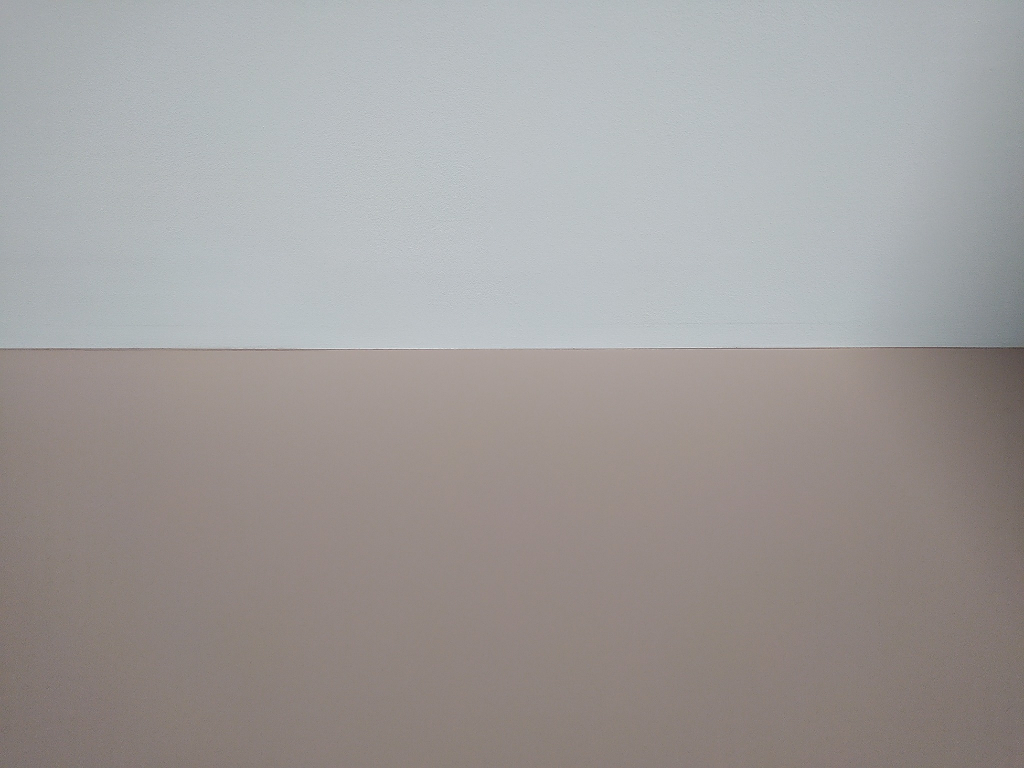 Ściana wewnętrzna pomalowana na dwa kolory: górna część na jasny odcień szarości, dolna na beżowo-brązowy. Widoczna faktura ściany.