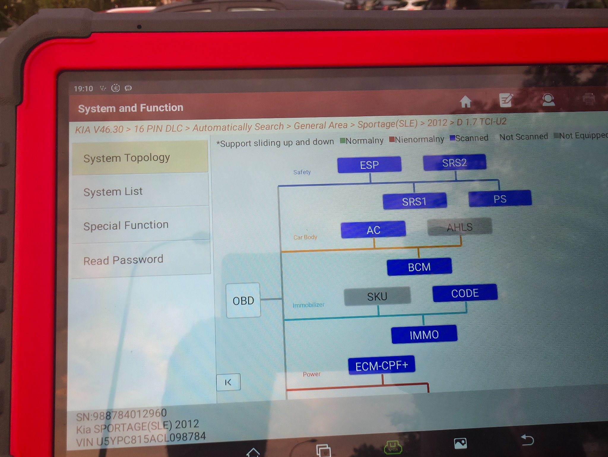 Tablet z diagramem diagnostycznym systemów KIA Sportage (2012) z modułami ESP, SRS, AC, BCM, OBD, IMMO. Widoczne opcje: System Topology, Read Password.