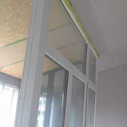 Montaż okien balkonowych z widoczną płytą OSB na suficie i surowymi ścianami z płyt gipsowo-kartonowych