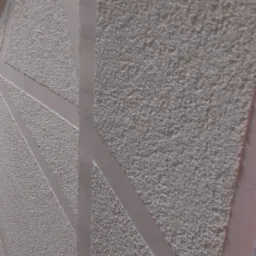 Szara, ziarnista elewacja z geometrycznym wzorem w postaci jasnych pasów