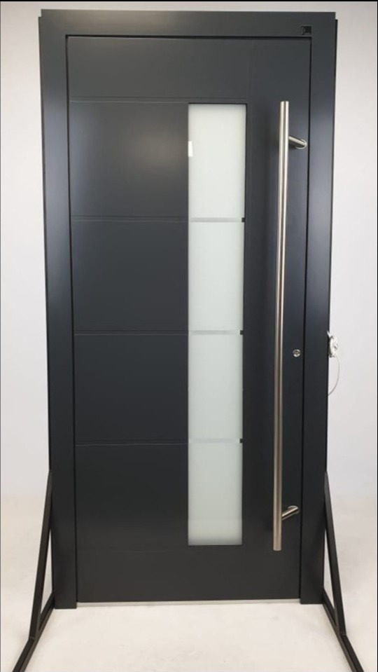 Nowoczesne, grafitowe skrzydło z pionowym, matowym przeszkleniem i długim, srebrnym uchwytem, ustawione na metalowej ramie ekspozycyjnej.