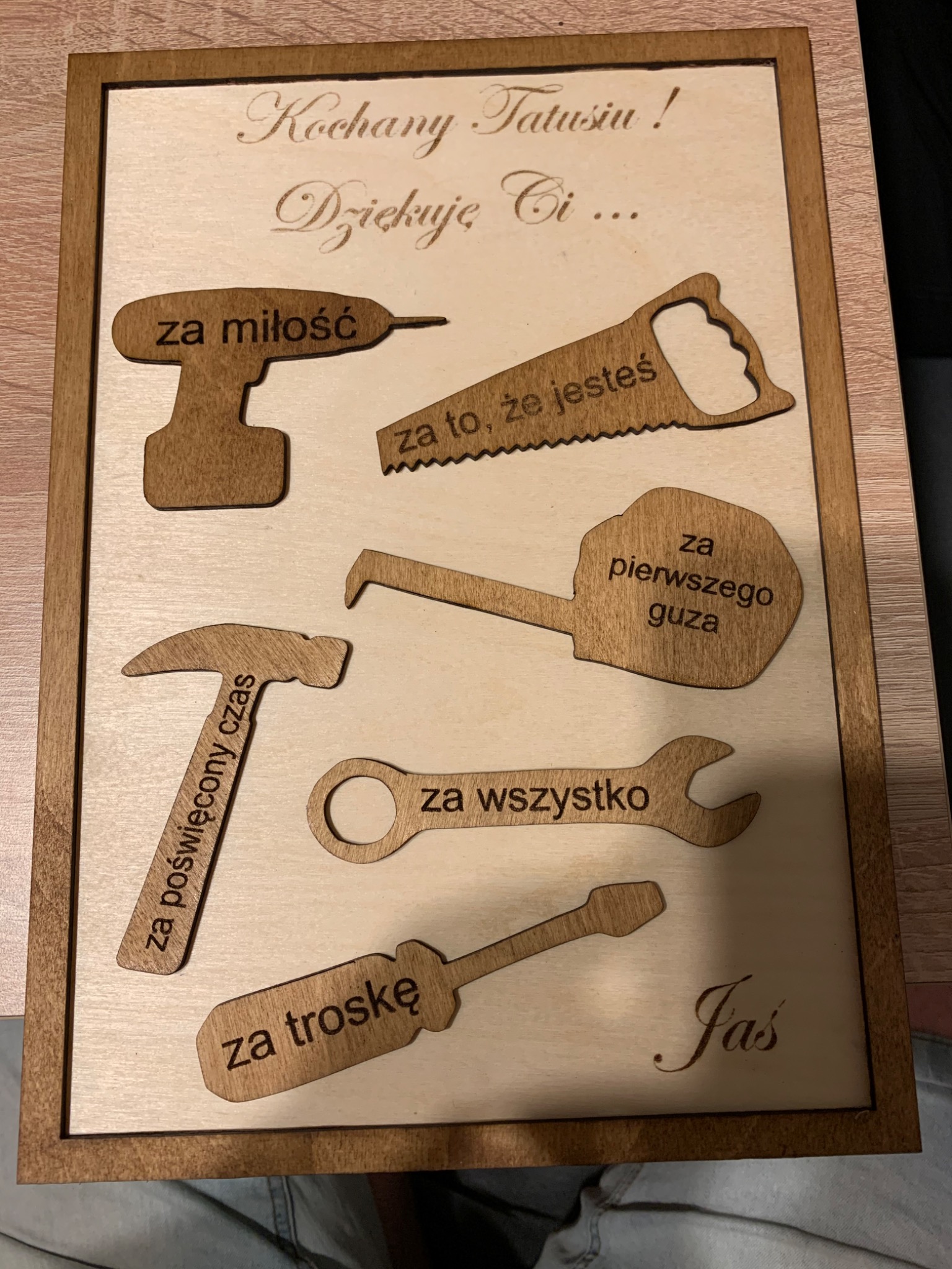 Drewniana tabliczka z wygrawerowanymi narzędziami i napisem 'Kochany Tatusiu! Dziękuję Ci...' z dedykacjami 'za miłość', 'za to, że jesteś', 'za poświęcony czas', 'za pierwszego guza', 'za...