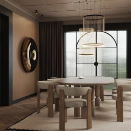 Pina-Studio.pl Natalia Piątkowska - Elegancka jadalnia we Wrocławiu: okrągły stół, krzesła z drewnianymi nogami, designerskie lampy wiszące i dekoracja ścienna w złotym kolorze.