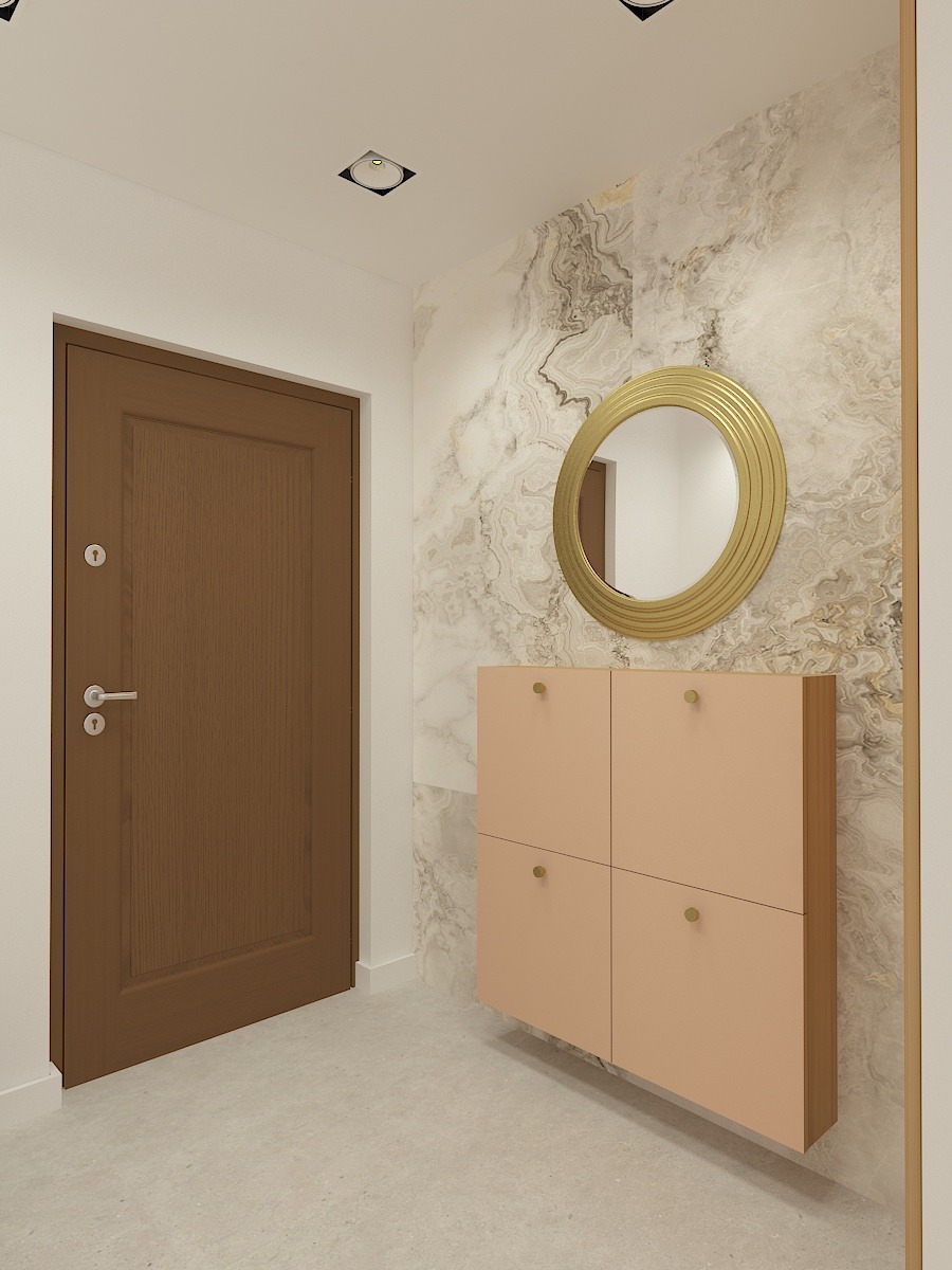 Nowoczesny przedpokój z brązowymi drzwiami, szafką na buty w odcieniach brzoskwini i okrągłym lustrem w złotej ramie na ścianie wykończonej marmurkowym wzorem.