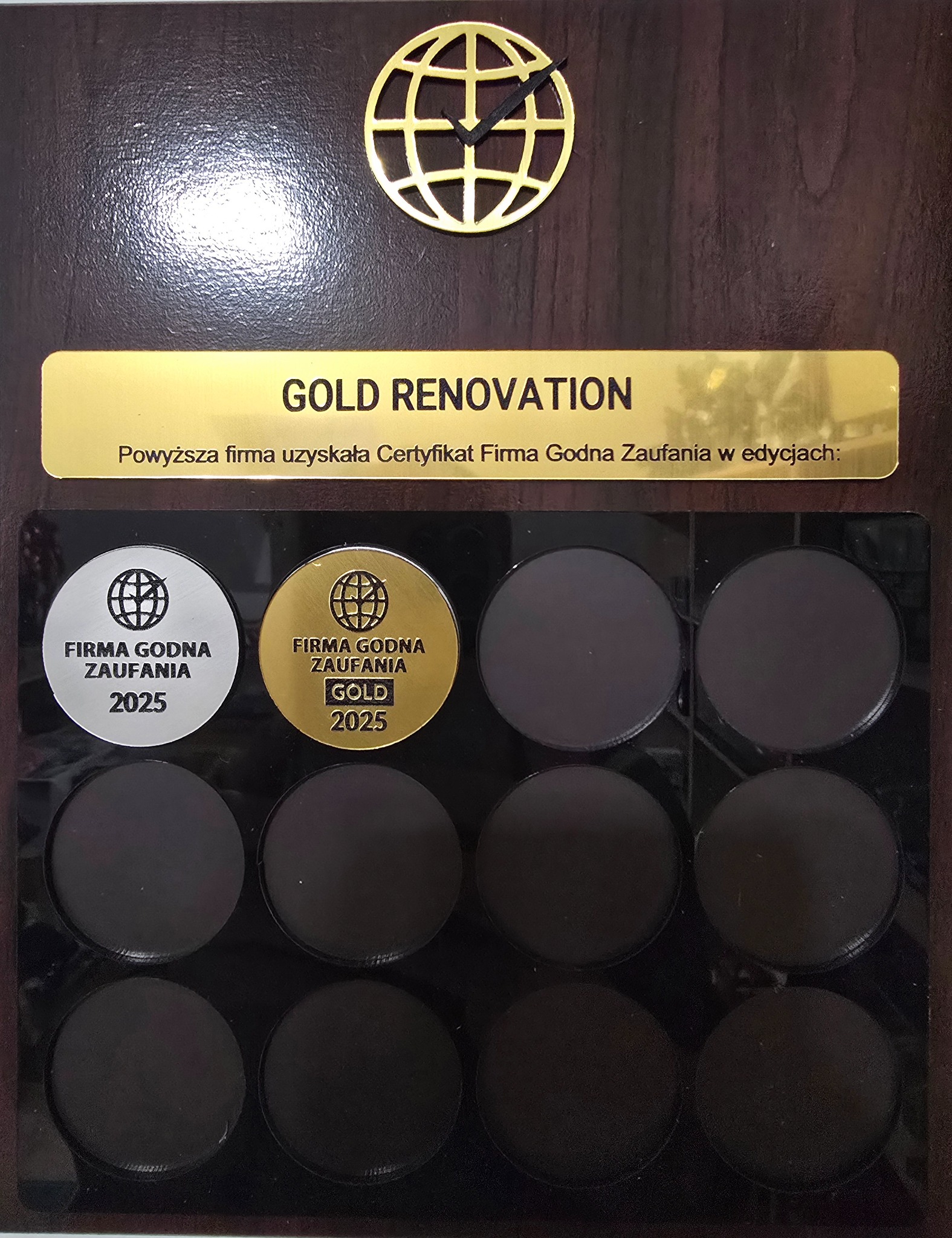 Tablica z certyfikatami 'Firma Godna Zaufania' dla 'GOLD RENOVATION', edycje 2025, na ciemnobrązowym tle z logo firmy w formie globusa.