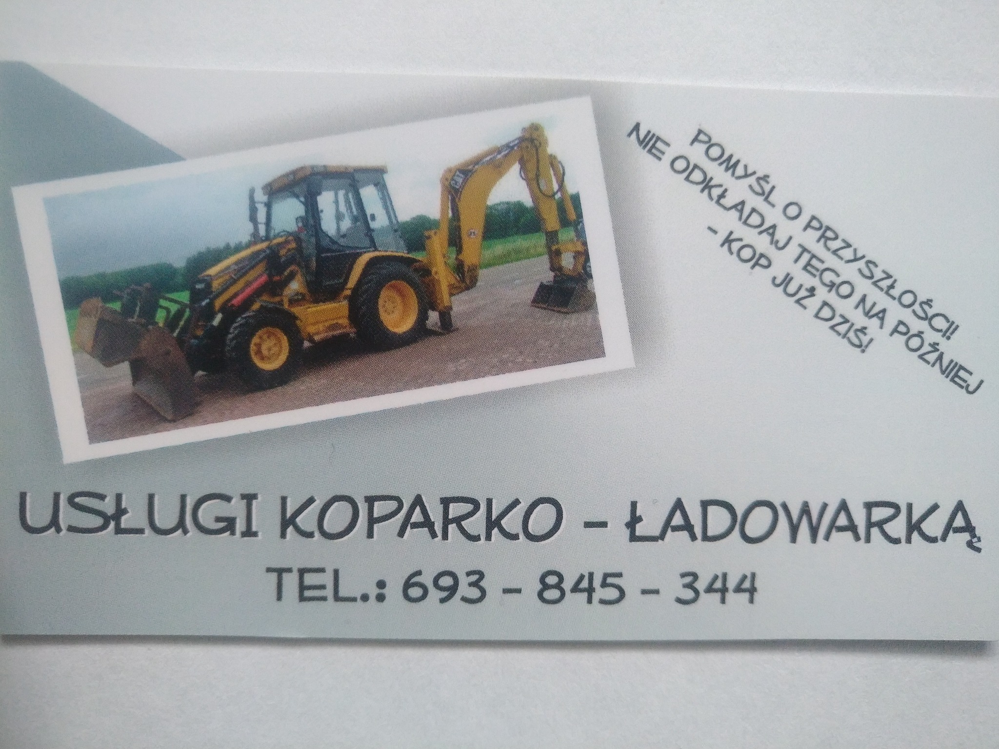 Wizytówka firmy oferującej usługi koparko-ładowarką, prezentująca zdjęcie żółtej maszyny budowlanej na tle zieleni, z hasłem 'Pomyśl o przyszłości! Nie odkładaj tego na później - Kop już dziś!'