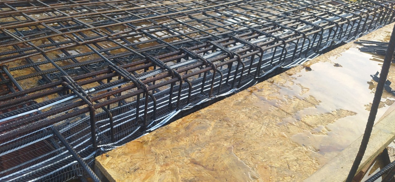 Siatka zbrojeniowa ułożona na płycie szalunkowej, przygotowana do zalania betonem.