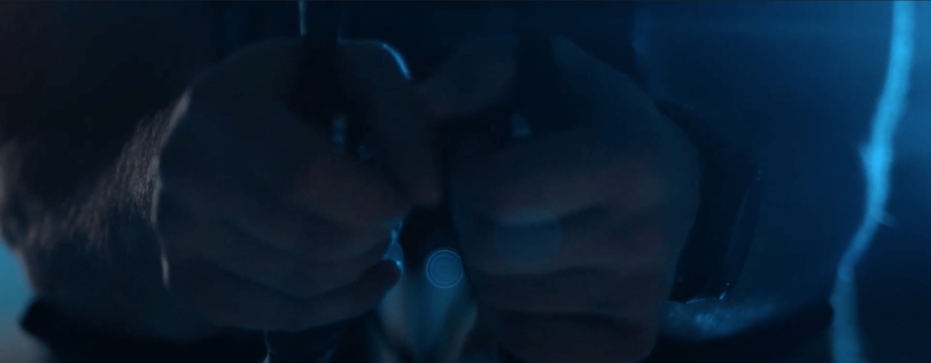 Ujęcie dłoni w niebieskim oświetleniu, prawdopodobnie fragment filmu lub teledysku.
