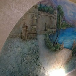 Listek Ogrody - Dekoracyjna ściana w Warszawie z efektem 3D, przedstawiająca pejzaż z zamkiem nad jeziorem i żaglówką. Unikalna faktura i malowanie tworzą iluzję głębi.