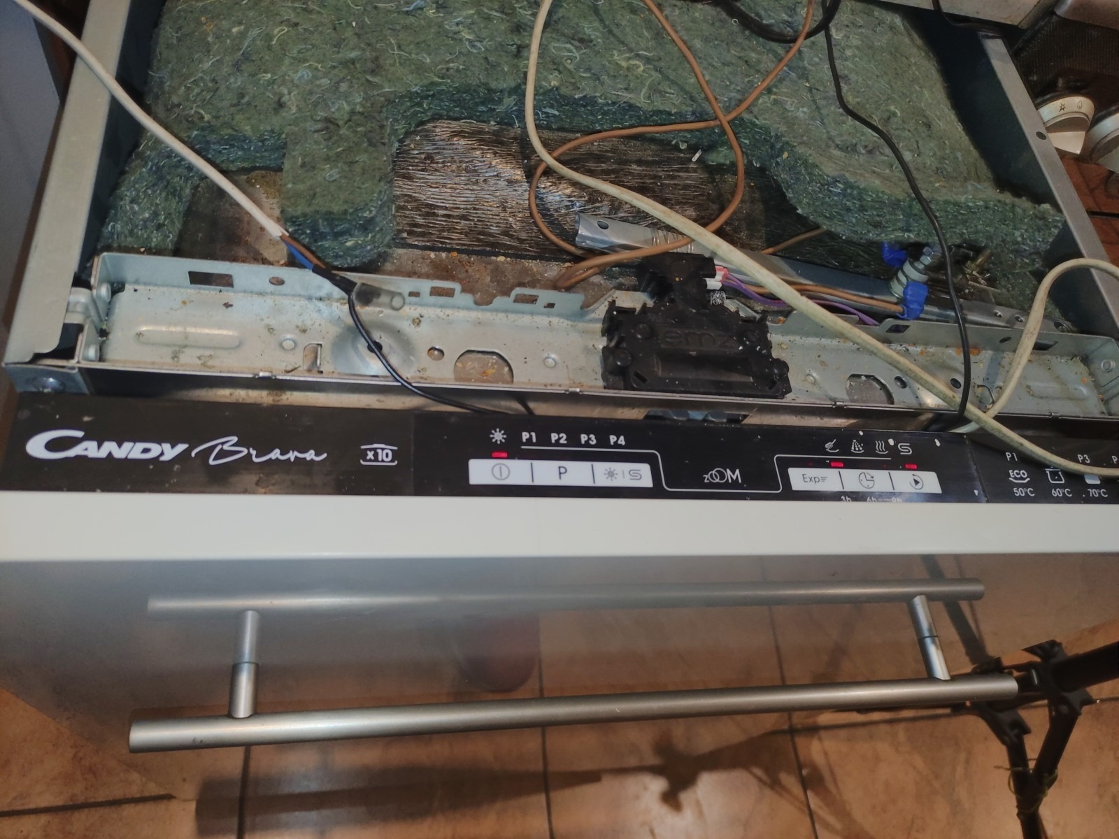 Otwarta zmywarka Candy Brava z widocznym panelem sterowania i wnętrzem z przewodami, w trakcie naprawy.