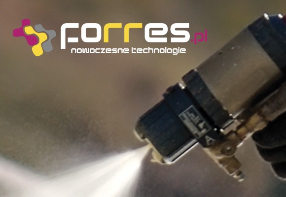 Aplikacja pianki natryskowej PUR za pomocą pistoletu natryskowego, widoczne logo firmy na górze kadru.