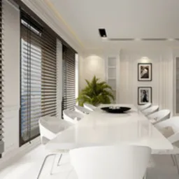 Elegancka jadalnia z białym stołem i krzesłami, oświetlona naturalnym światłem wpadającym przez drewniane poziome osłony okienne, z widoczną rośliną doniczkową w tle i dwoma portretami na ścianie.