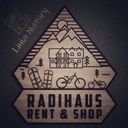 Linia Natury - Drewniane logo Radhaus Rent & Shop z grafiką przedstawiającą góry, dom, drzewa, narty i rowery, stylizowane na grawerowane.